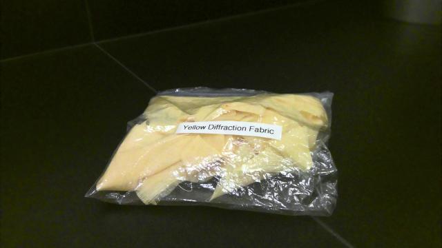 A bag with yellow cloth inside of it and a label "Yellow Diffraction Fabric"