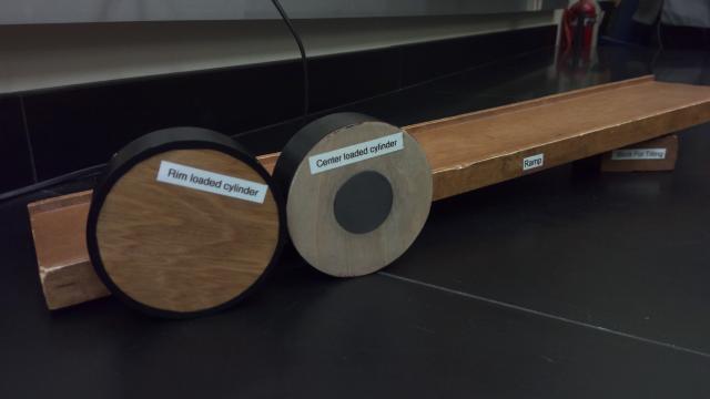 Two different disks in front of a ramp tilted with a wooden block underneath