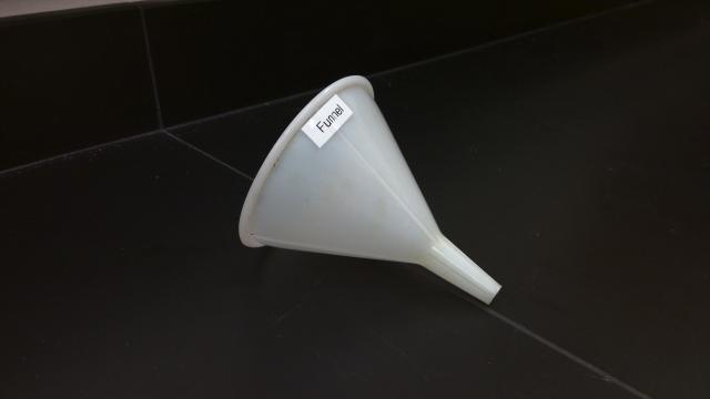 A plastic funnel with black background