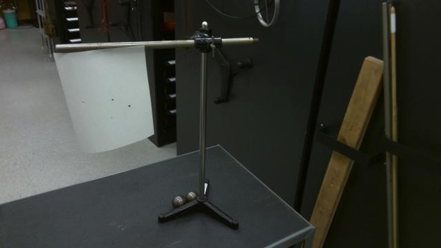 The kinetic energy into fire demonstration with steel balls, a stand with vertical and horizontal rods and a piece of paper attached