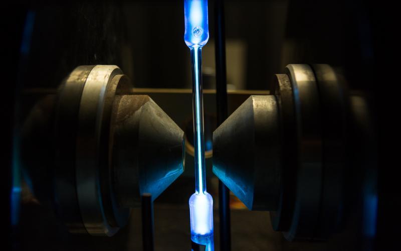 A close up of a glowing blue liquid in a glass tube
