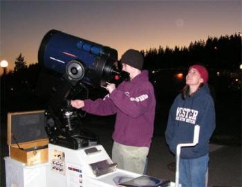 Two students looking through a telescope